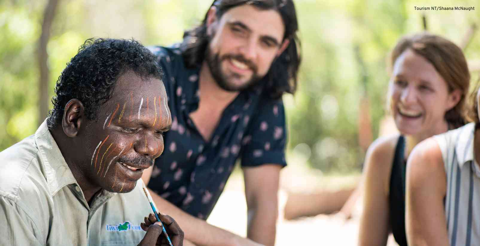 First Nations man painting his face