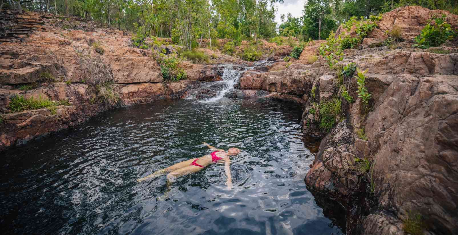 Woman Floating in swimming hole