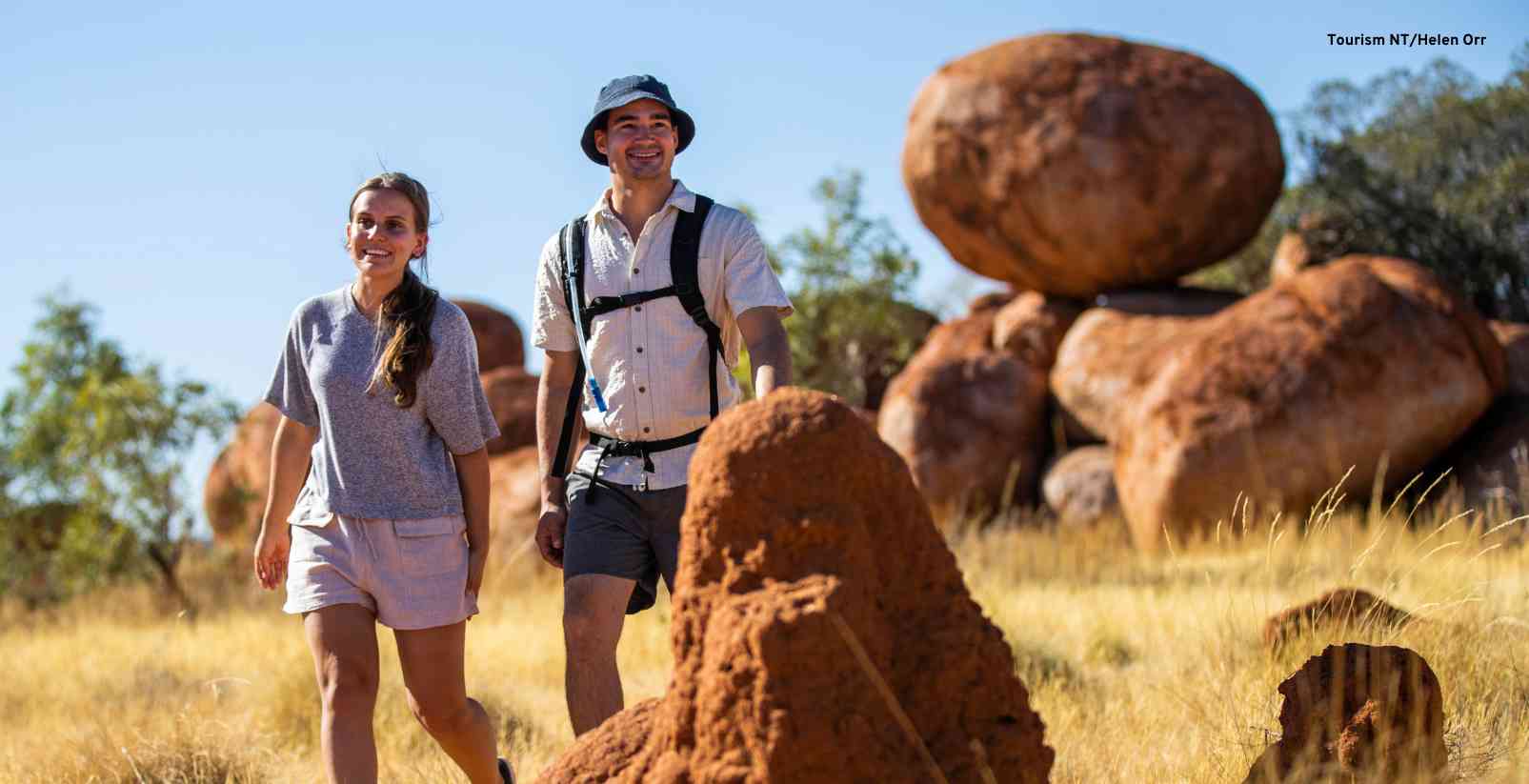 man and woman walking through the Kalu Kalu - The Devil's Marbles in the Northern Territory